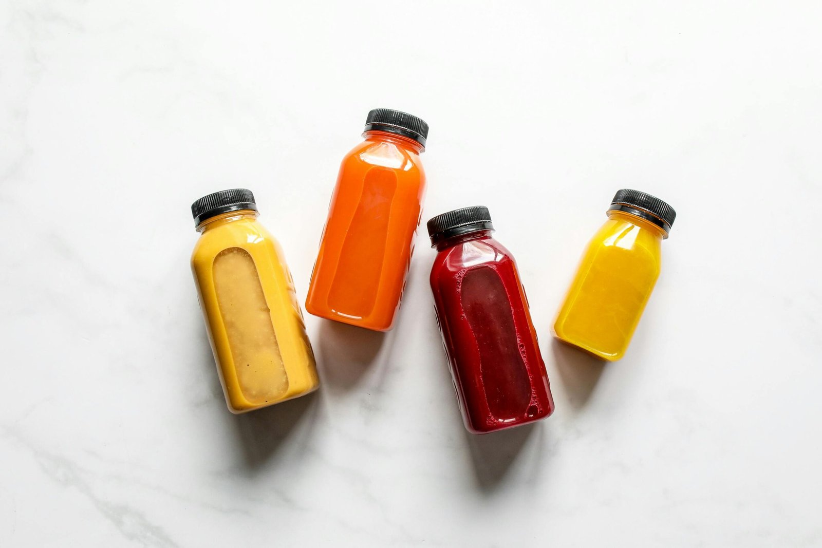 Colorful smoothies in bottles on a white background, ideal for healthy lifestyle concepts.